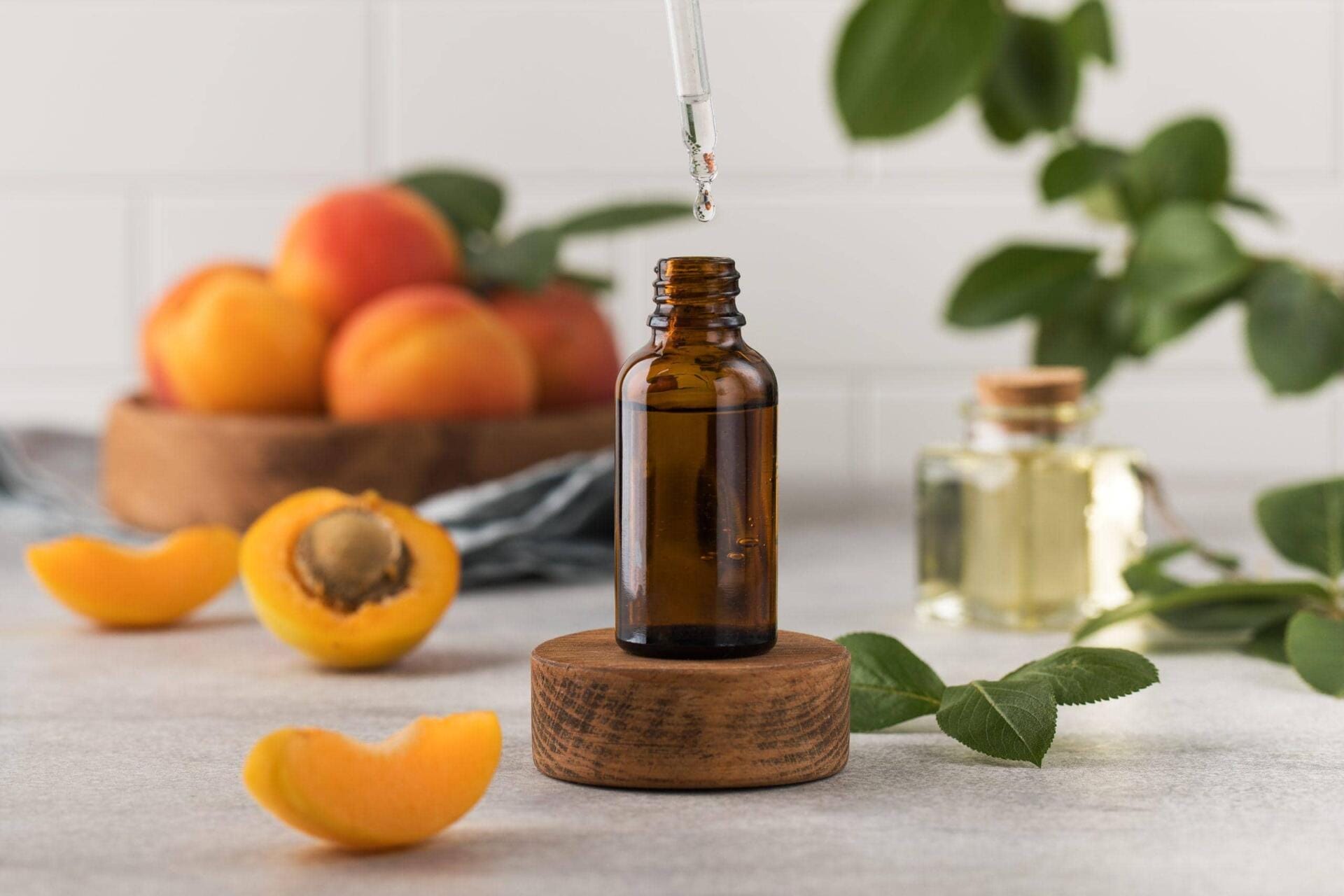 a drop of skin care serum is dripping from a pipette into a bottle. oil with apricot kernel extract to nourish the skin