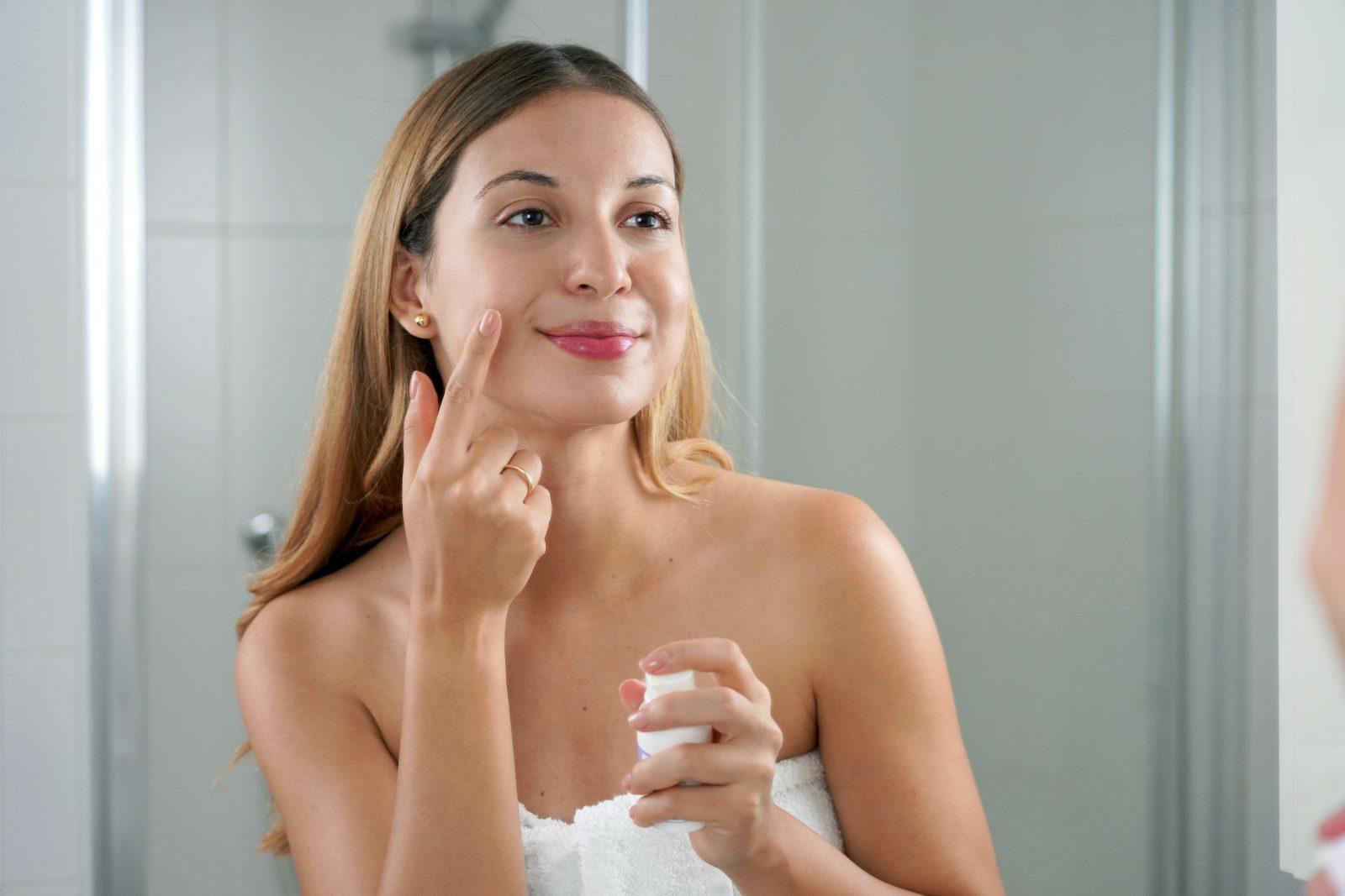 skin care woman applying cream with retinol anti signs in the ba