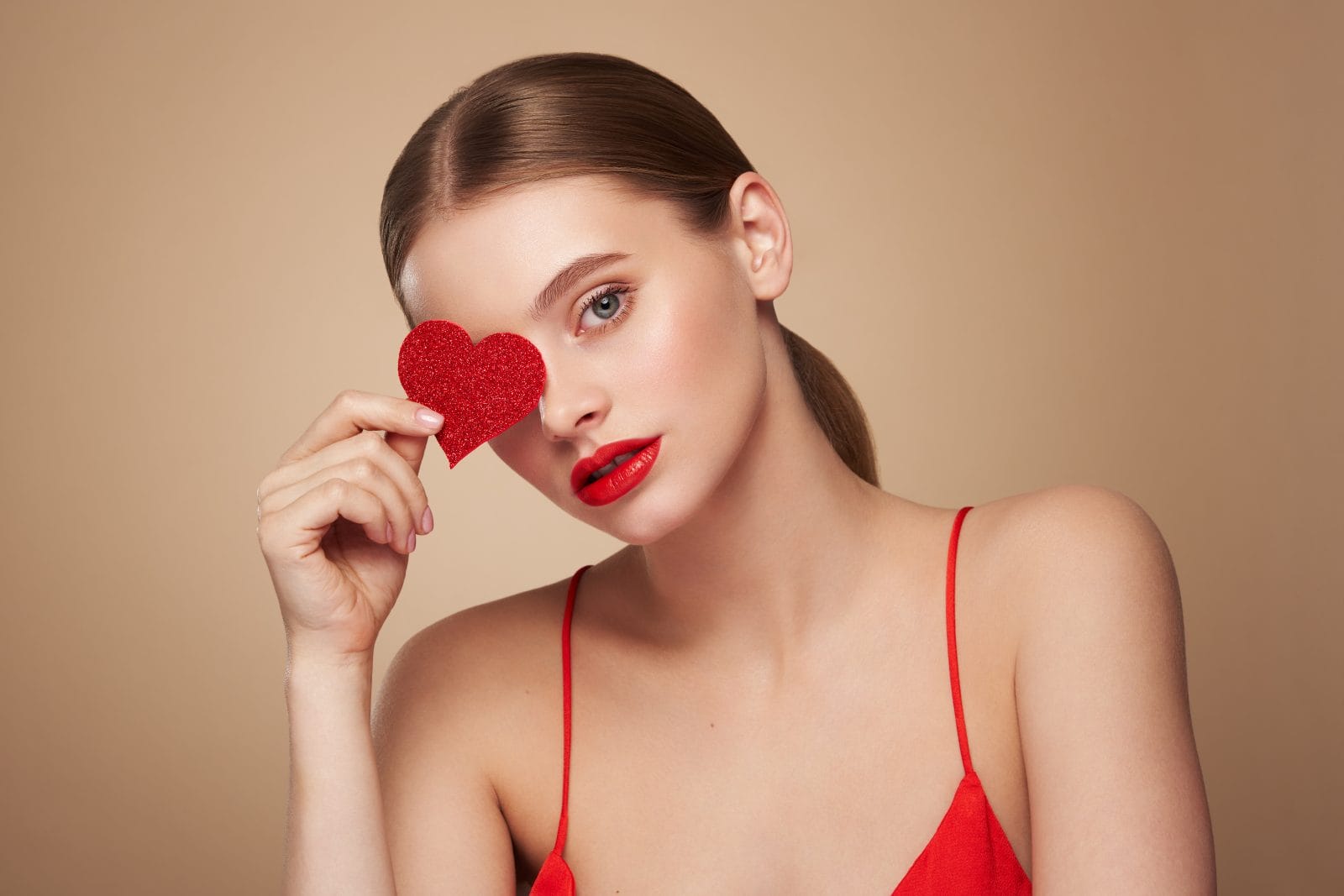 beautiful woman holding an artificial red heart